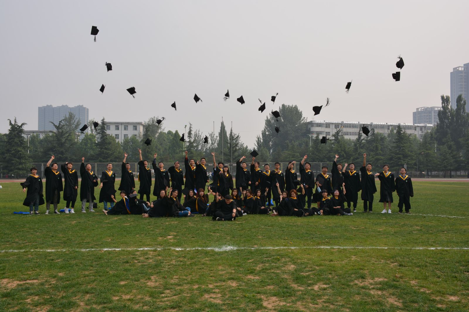 Graduates in gowns with a city skyline behind them