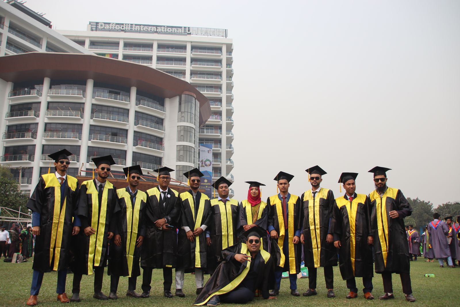 Graduates in gowns celebrating in front of a city skyline