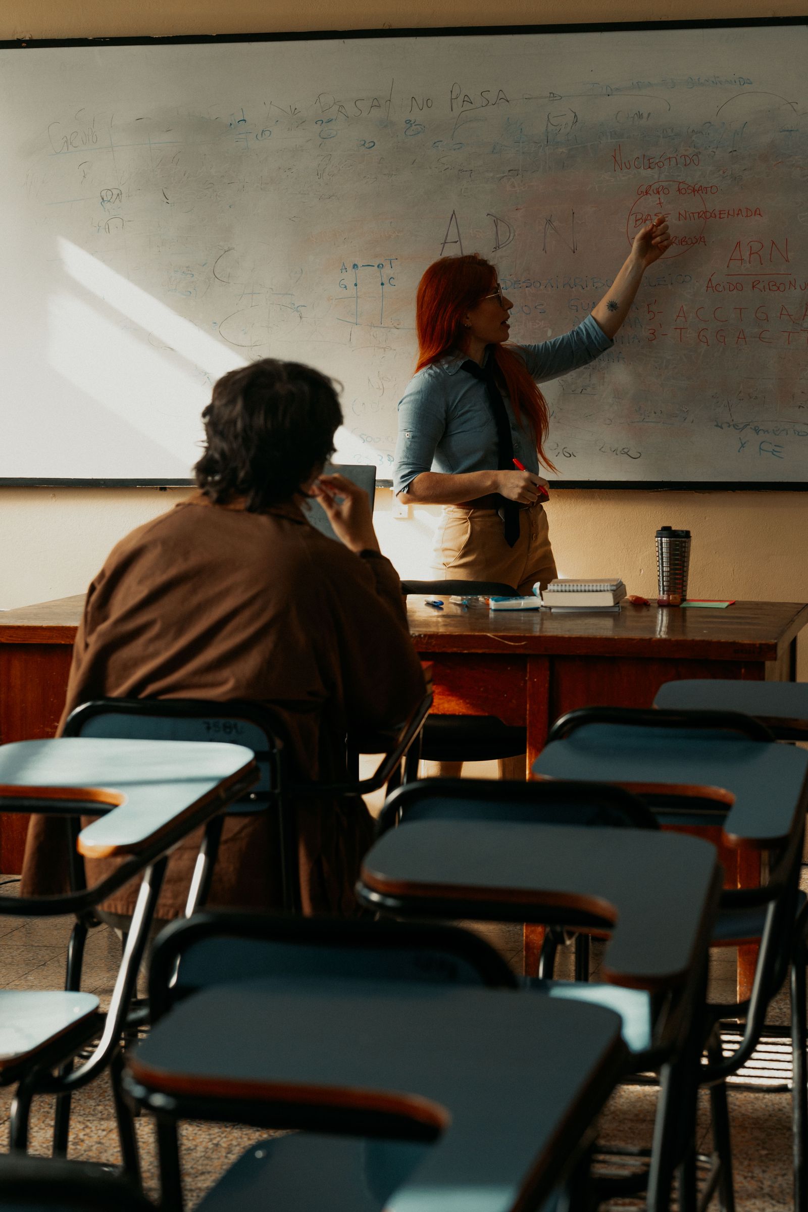 A presenter at a lectern in a seminar room with an audience