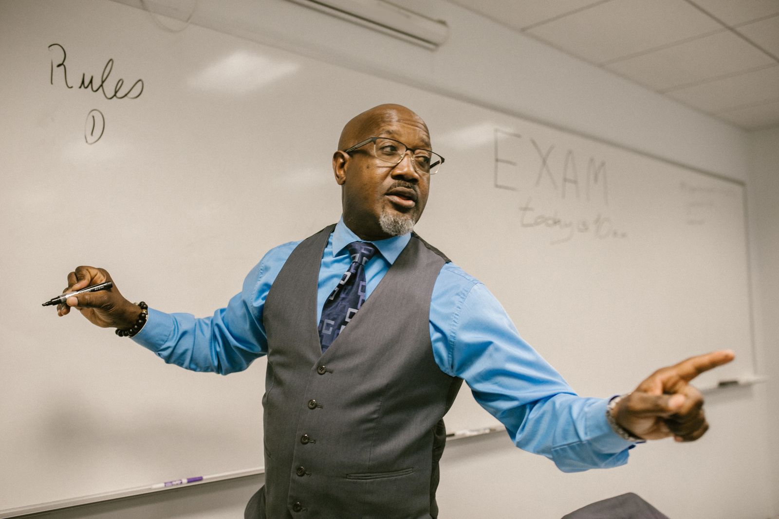Senior professor reviewing work on a laptop in a university lecture theatre