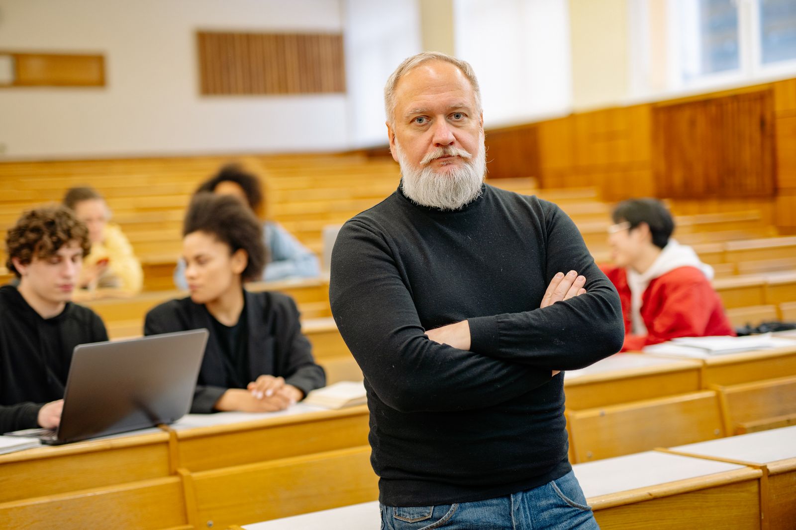 Senior professor working on a laptop in a lecture theatre