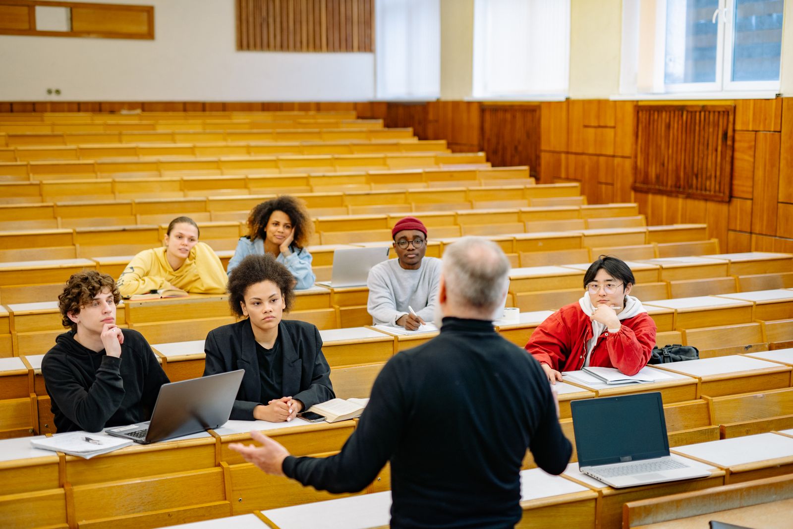 Senior professor working on a laptop in a lecture theatre