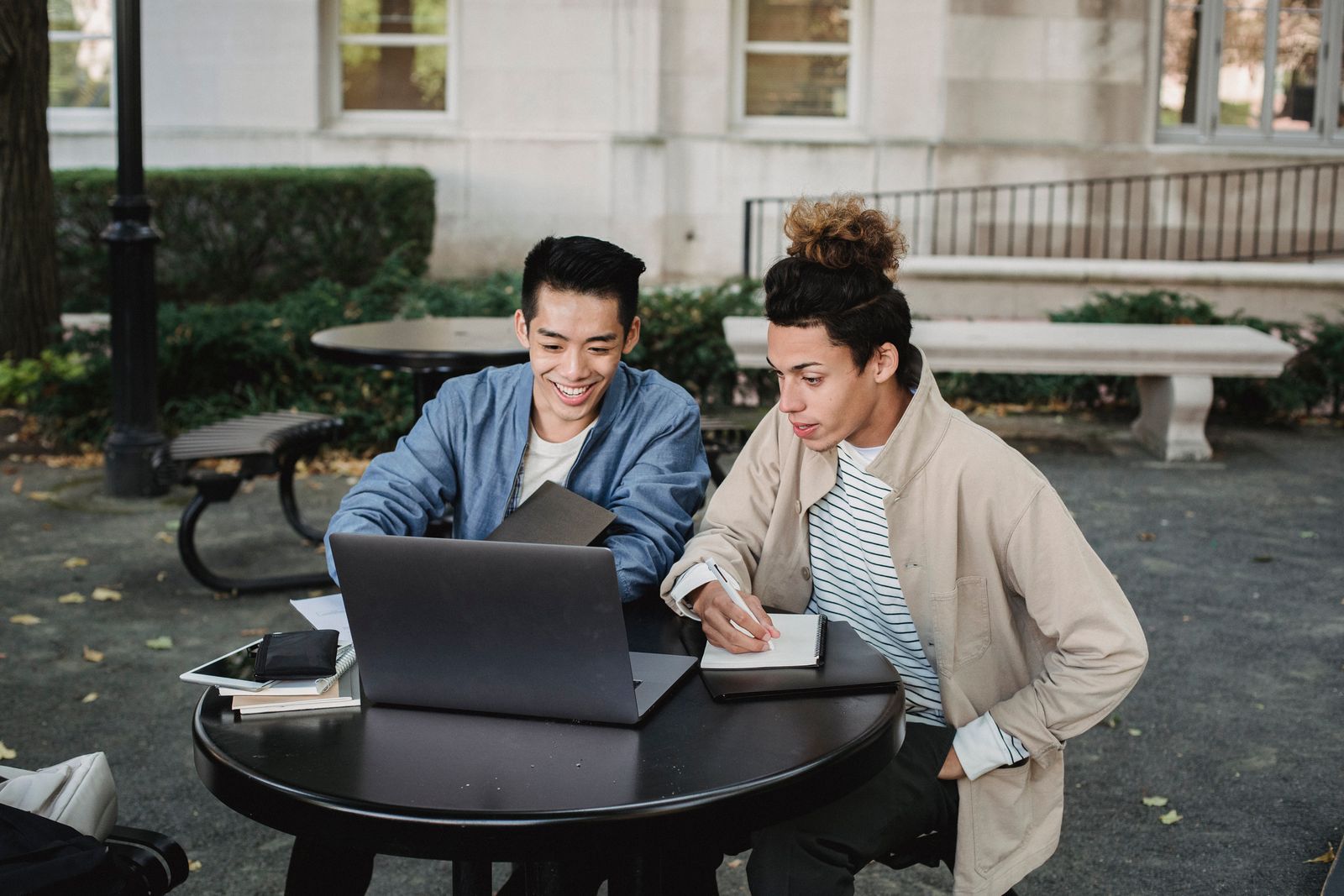 Students collaborating around a table with a tablet and a laptop
